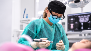 Odontóloga realizando un procedimiento dental en una clínica especializada en implantología dental.